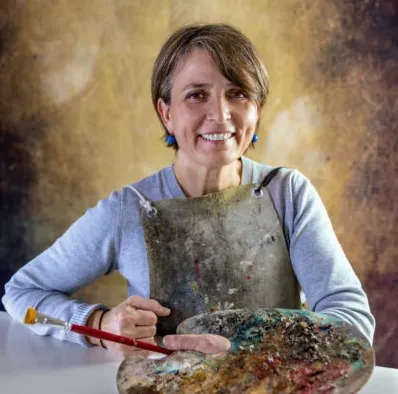 Ritratto di Nicoletta Bagatti in grembiule da lavoro, con tavolozza e pennello in mano